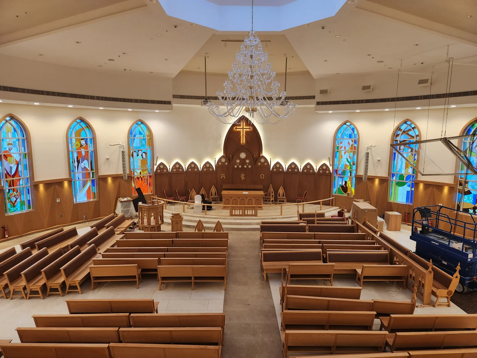 Blue, turquoise and amber stained-glass windows beside the altar, viewed from the balcony